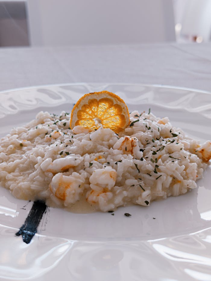 Delicious seafood risotto topped with a citrus slice, perfect for gourmet dining.