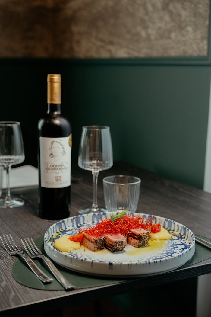 Savor a gourmet meal with wine in a cozy Calabrian setting, perfect for fine dining.